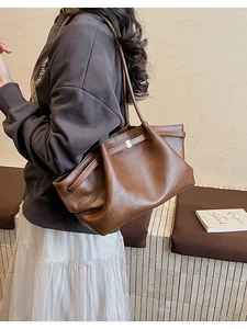 Détail d'un sac cabas marron foncé vintage avec fermeture à cordon et boucle argentée