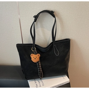 Détail du sac cabas noir mat avec surpiqûres blanches et breloque ours mignon