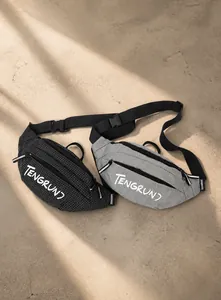 Close-up of black and grey waist bags with grid texture and adjustable nylon straps