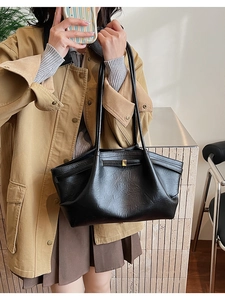 Gros plan détaillé d'un sac cabas plissé noir avec boucle dorée et texture cuir
