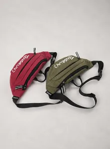 Detail of waterproof ripstop nylon waist bags in burgundy and army green with TENGRUN logo