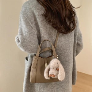 Khaki bucket bag with litchi grain leather and a cute plush rabbit pendant charm detail