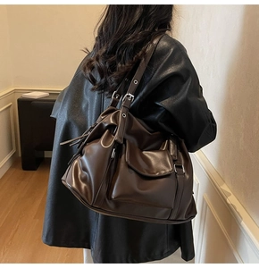 Close-up of vintage dark brown faux leather tote bag with silver buckle details