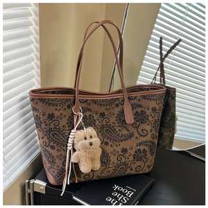 Close-up of vintage floral paisley tote bag with cute plush bear charm detail
