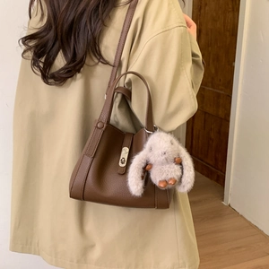 Brown lychee leather bucket bag with silver twist lock and pink bunny plush charm