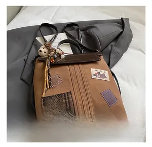Detail of a brown canvas backpack with cartoon patches and teddy bear charm accessory