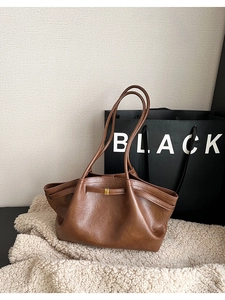 Vue détaillée du sac cabas marron avec texture cuir et boucle dorée élégante