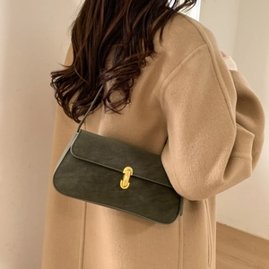 Detail of vintage dark green suede underarm bag with gold u-shaped buckle and fine strap