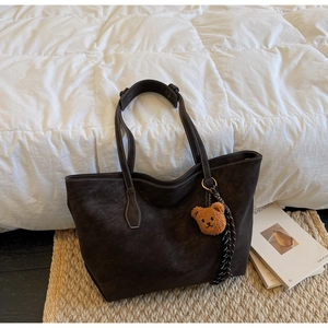 Vue détaillée du cabas en daim marron café avec surpiq coutures contrastées blanches et breloque ours