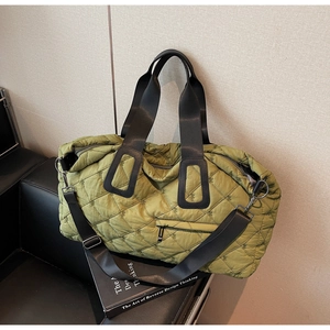 Detail of olive green quilted nylon travel bag featuring crossbody strap and side zipper