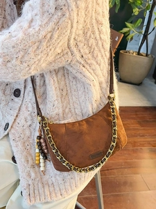 Brown faux suede crescent bag with gold chain and vintage bead charm for women