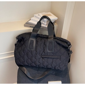 Detail of black quilted sports bag with diamond stitching and adjustable shoulder strap