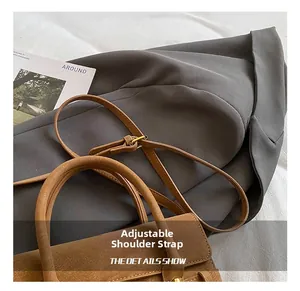 Dettaglio della tracolla regolabile con fibbia in metallo su borsa vintage marrone