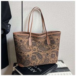 Detailed view of paisley pattern on large faux leather tote bag with long shoulder straps