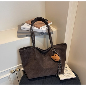 Détail du grand sac cabas mat marron foncé avec pendentif ours et surpiqûres