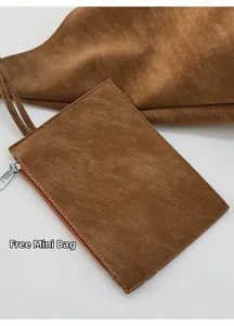 Detail of the brown leather mini pouch with metal zipper and hanging strap accessory