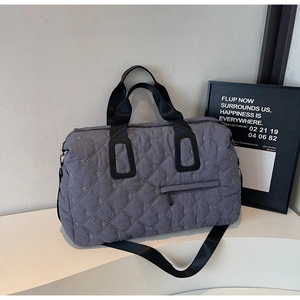 Detailed side view of grey-purple quilted travel bag with cross pattern and black straps