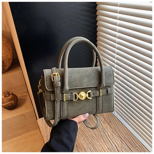 Detail of vintage gray-green crossbody bag featuring golden heart buckle and fine stitching