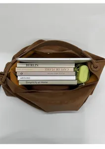 Top view showing large capacity interior of brown tote bag with books and tablet