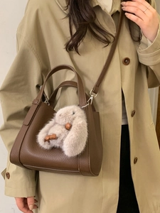 Brown litchi grain leather bucket bag with cute plush bunny charm and shoulder strap