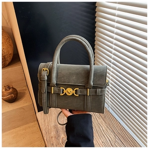 Close-up of retro olive green crossbody bag featuring a golden heart-shaped metal clasp