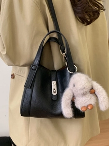 Chic black pebbled leather bucket bag with silver clasp and cute plush rabbit charm