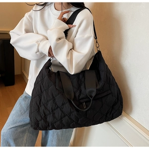 Detail of black quilted tote bag featuring floral embroidery and high-density fabric