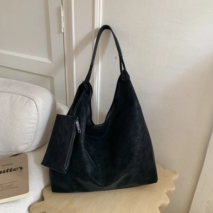 Détail d'un grand sac hobo noir minimaliste avec pochette zippée amovible et fini mat
