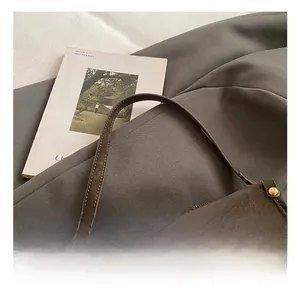 Detailed close-up of retro brown leather handbag showing metal buckle and handle texture