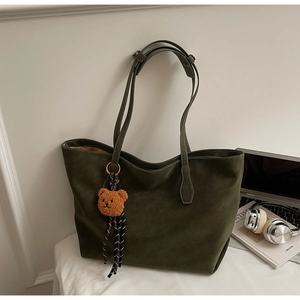 Détail du grand sac cabas en daim vert olive avec breloque ours en peluche marron
