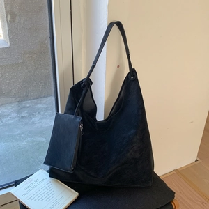 Gros plan d'un sac hobo en daim noir avec pochette zippée et bandoulière assortie