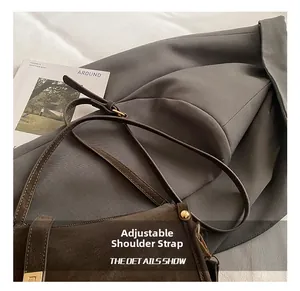 Close-up of the vintage brown leather bag with adjustable strap and golden buckles