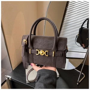 Detail of vintage coffee brown crossbody bag with gold hardware and textured leather finish