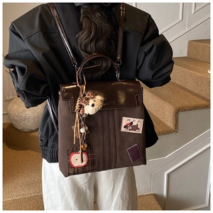 Détail du sac à dos vintage en toile avec écusson chiot MDD et breloque ours en peluche
