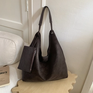 Détail d'un grand sac Hobo marron foncé en cuir vintage avec une petite pochette assortie