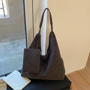 Détail d'un grand sac cabas en similicuir marron avec une petite pochette assortie
