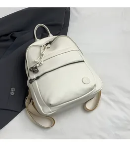 Close-up of white lychee texture leather backpack with dual zippers and round embossed logo