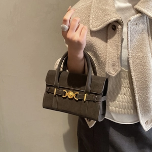 Detail of a taupe matte mini handbag with elegant gold interlocking metal buckle hardware