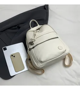 White pebbled leather backpack detail showing capacity with iPad and smartphone