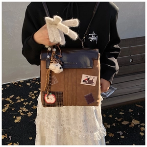 Détail d'un sac à dos rétro en toile avec breloques de chien et patchs MDD sur un banc