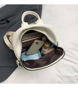 Spacious interior of white lychee leather backpack with phone and cosmetics