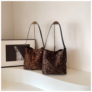 Detail view of leopard print tote bags in warm and cool tones with leather straps