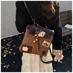 Detail of vintage brown patchwork backpack featuring cute patches and plush bear charms