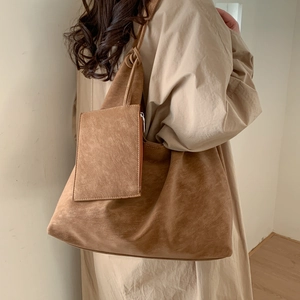 Détail d'un grand cabas en daim marron avec petite pochette zippée sur la bandoulière