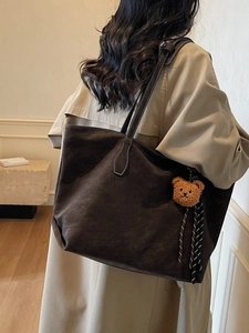 Grand cabas en daim marron avec surpiqûres blanches et ours en peluche porté à l'épaule