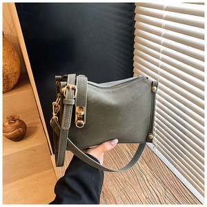 Close-up of vintage dark green crossbody bag with gold hardware and matte finish