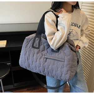 Detail of dark grey quilted sports bag with diamond stitching and adjustable nylon strap
