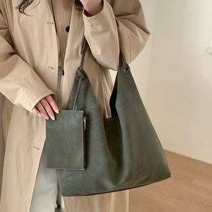 Détail d'un grand cabas vert olive foncé avec pochette zippée assortie sur un manteau
