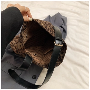 Close-up of leopard print tote bag interior with striped lining and black shoulder strap