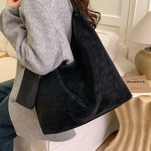 Détail d'un grand cabas noir en daim avec une petite pochette assortie pour le quotidien